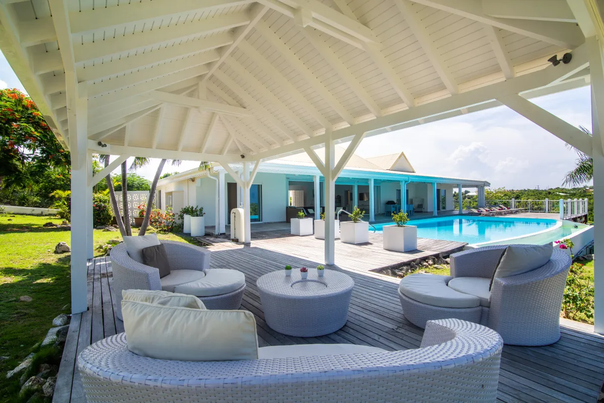 Villa Callisto: Covered gazebo lounge with woven seating on a wooden deck beside a swimming pool