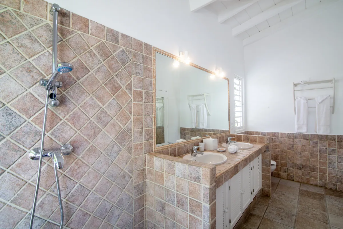 Villa Callisto: Double vanity and tiled shower area in a bright bathroom