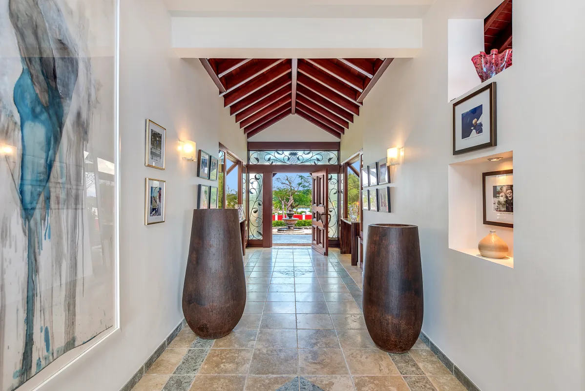 Villa Casa de la Playa: Tiled entrance hallway with vaulted wood ceiling, artwork, large urns, and open door