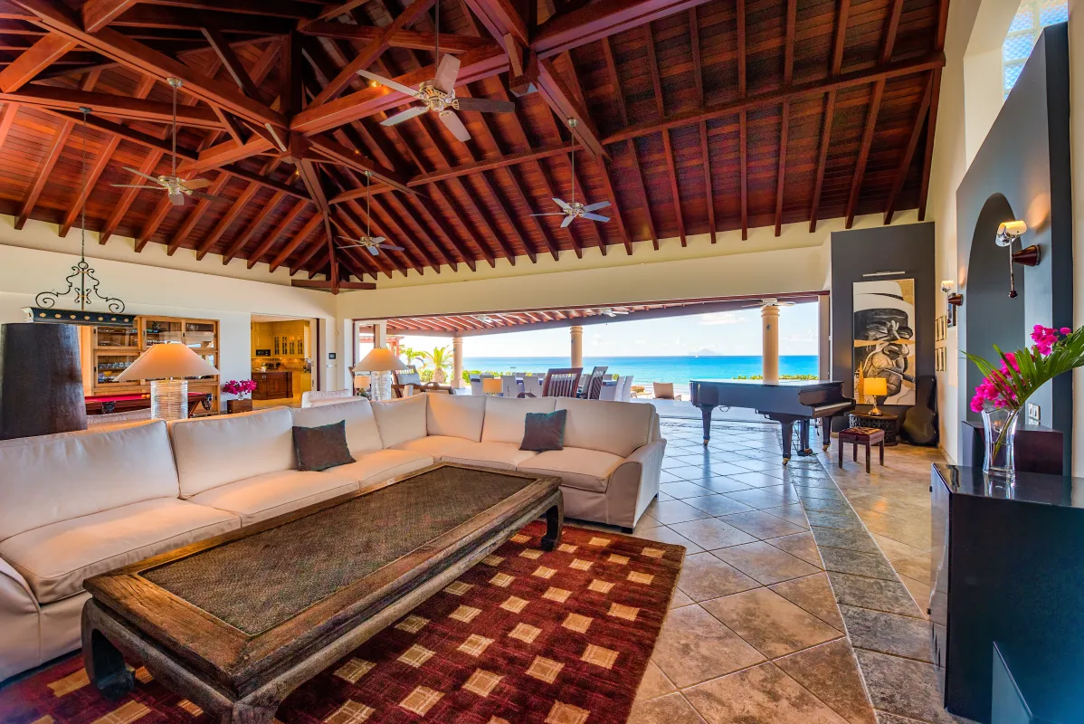 Villa Casa de la Playa: Open living room with high wood ceiling, large sectional sofa, piano, and ocean view