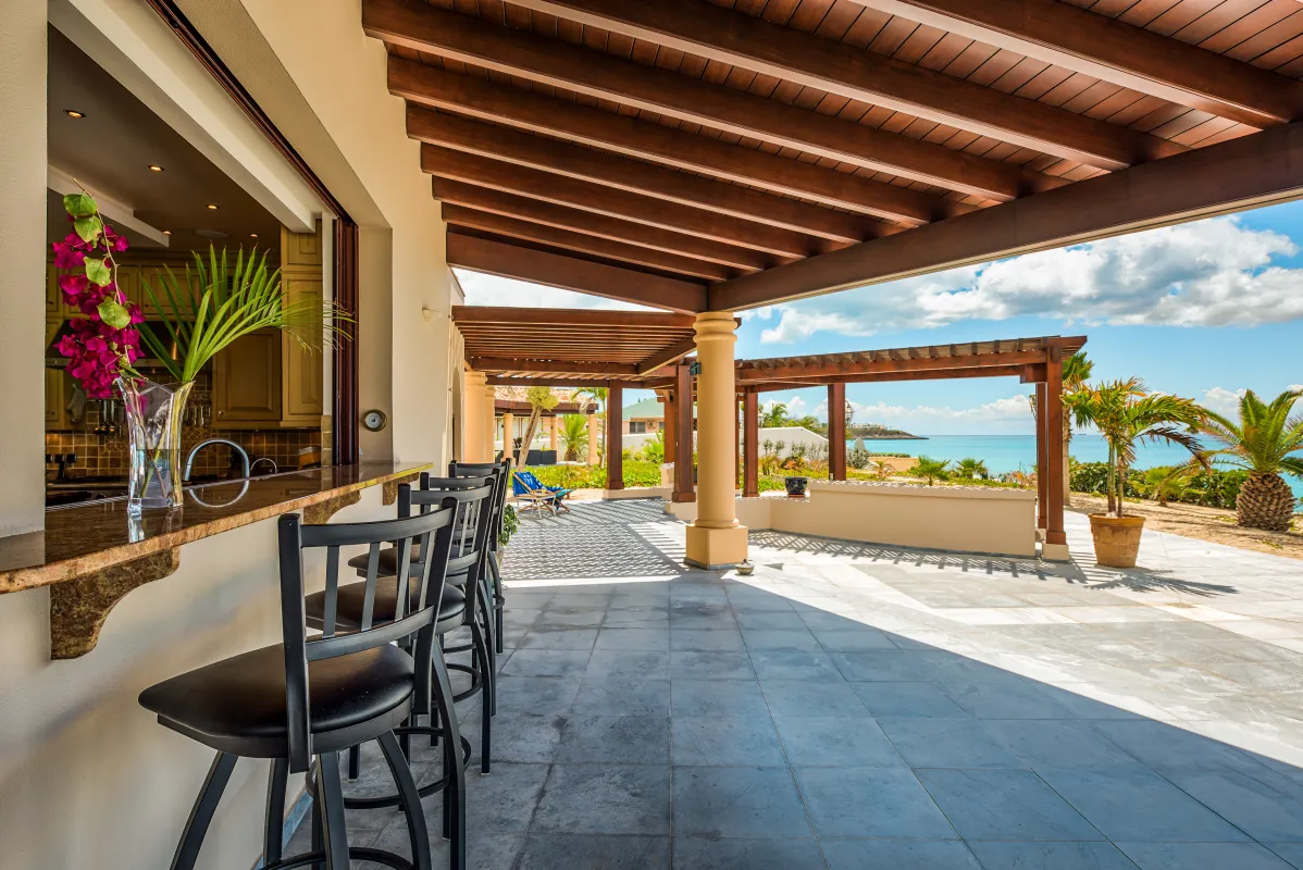 Villa Casa de la Playa: Covered patio bar with stools overlooking pergolas and the turquoise sea