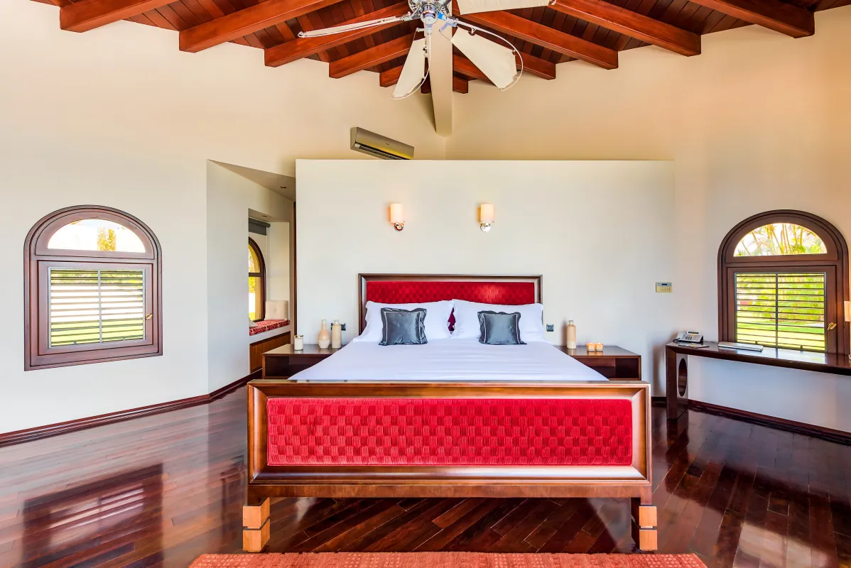 Villa Casa de la Playa: Bedroom with a red upholstered bed and high vaulted wood ceiling