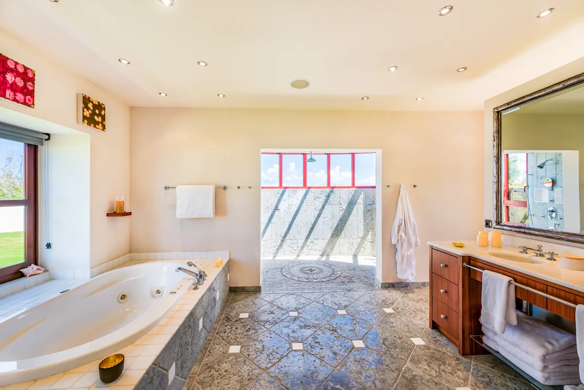 Villa Casa de la Playa: Spacious bathroom with a sunken bathtub, vanity sink, and opening to an outdoor shower