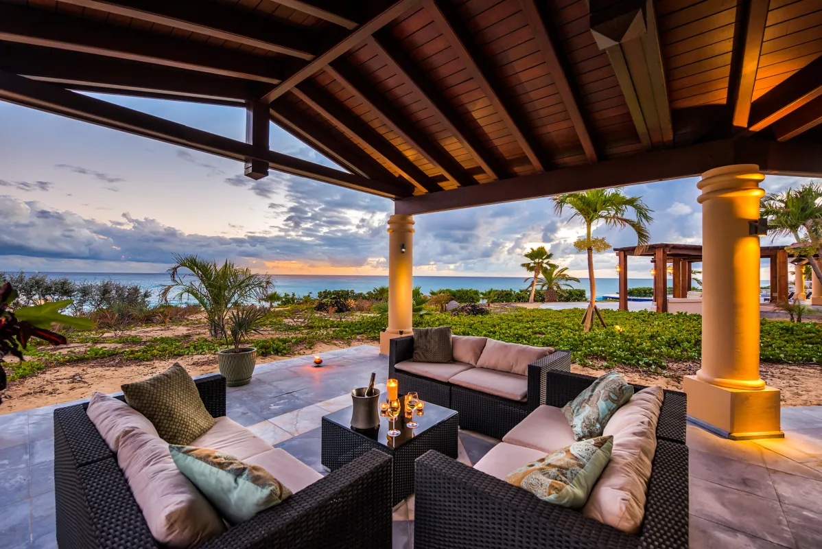 Villa Casa de la Playa: Covered patio lounge with wicker sofas overlooking the ocean at sunset