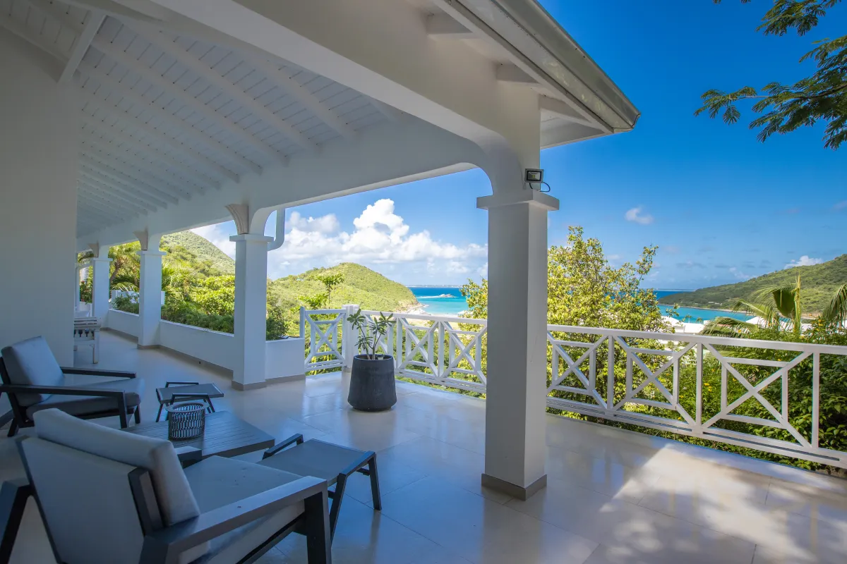Villa Casa Sand: Covered terrace with lounge seating overlooking lush hills and the turquoise sea