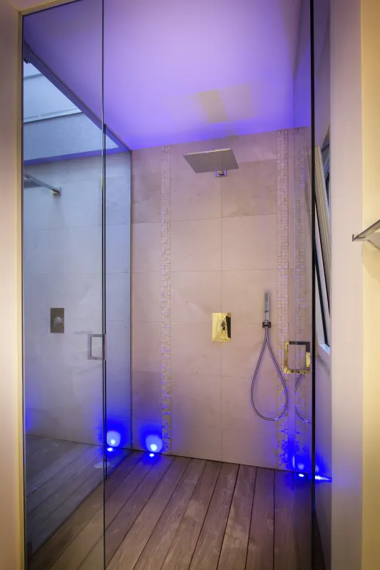Villa C'est la Vie: Modern walk-in shower with wooden deck flooring and blue ambient lighting