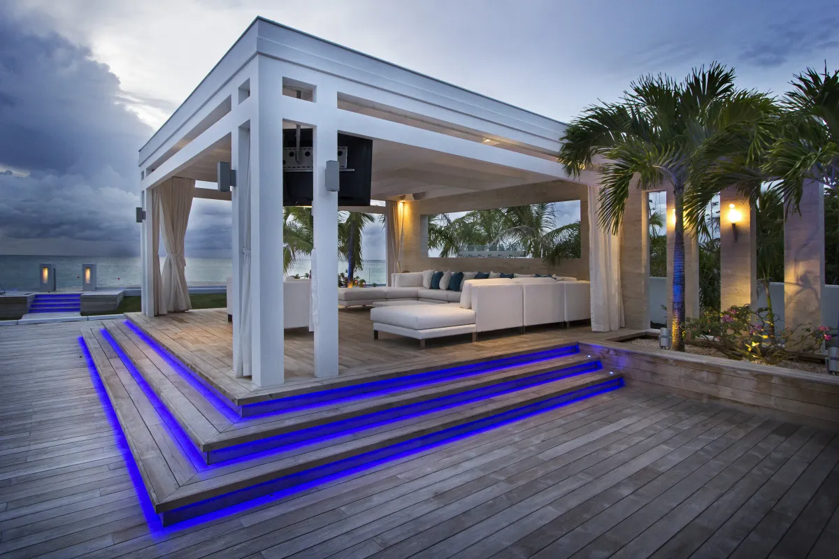 Villa C'est la Vie: Covered outdoor lounge with white sofas and blue step lighting on a wooden deck