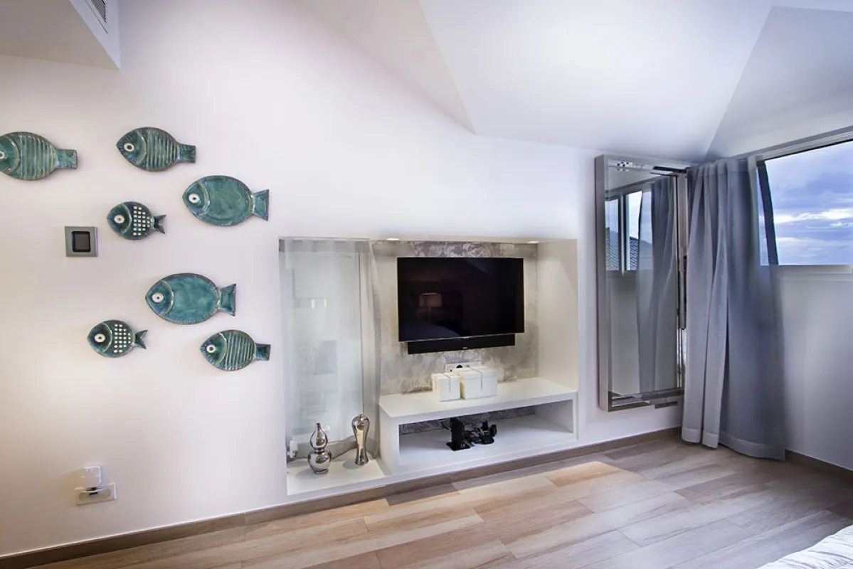 Villa C'est la Vie: Bedroom wall with fish-shaped ceramic decor and a television mounted in a built-in recess