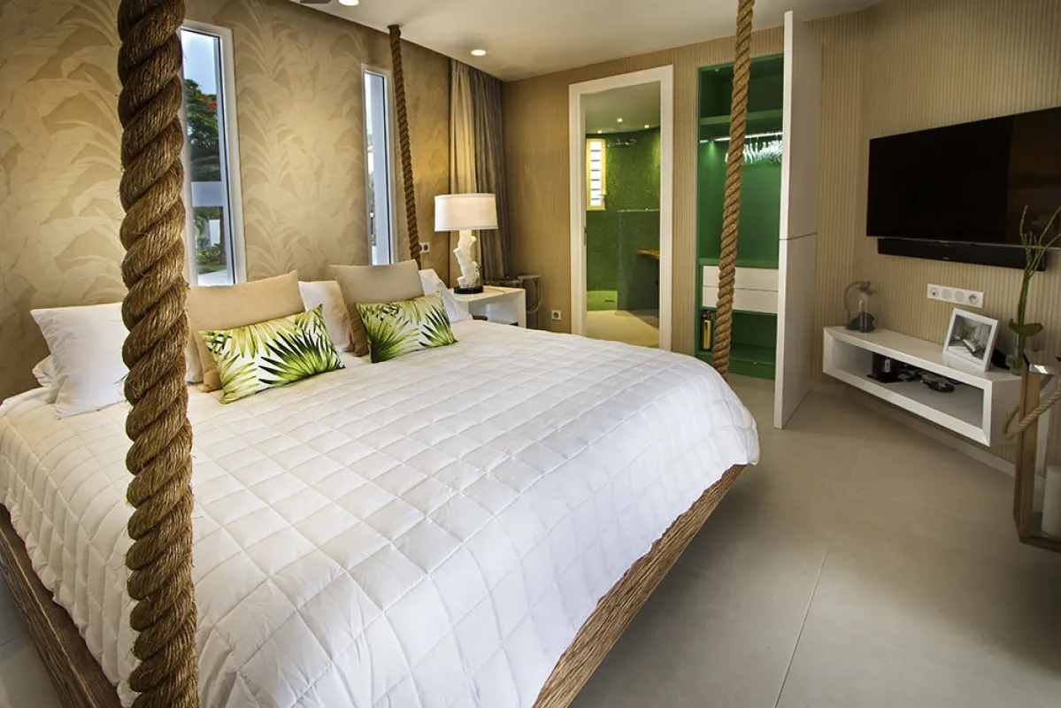 Villa C'est la Vie: Bedroom with a suspended bed hung by thick ropes and doorway to an ensuite bathroom