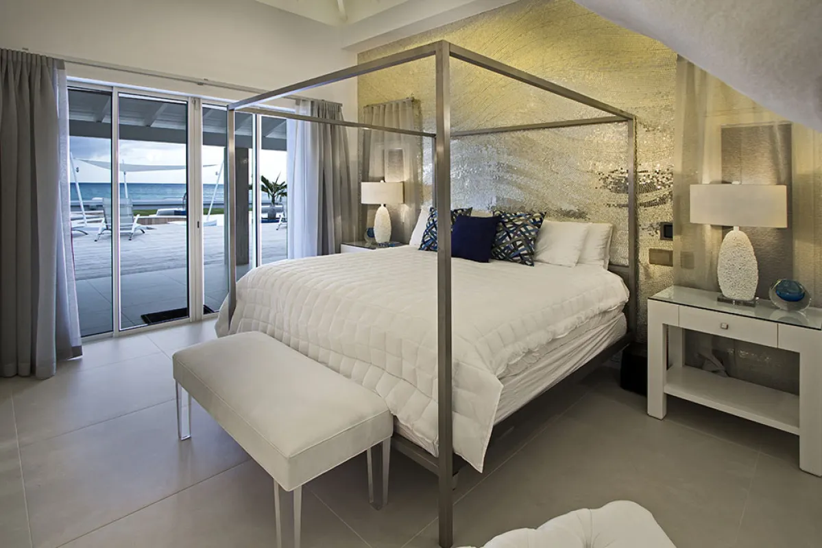 Villa C'est la Vie: Bedroom with canopy bed and sliding glass doors opening to the terrace