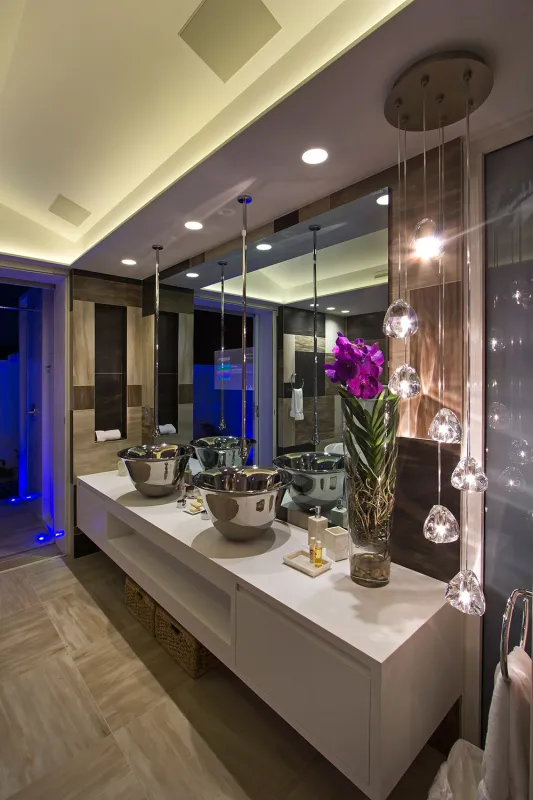 Villa C'est la Vie: Modern bathroom vanity with double vessel sinks, hanging pendant lights, and a purple orchid