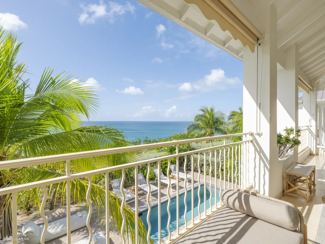 Villa Chez Paulette: Covered terrace balcony with daybed overlooking a swimming pool and the ocean