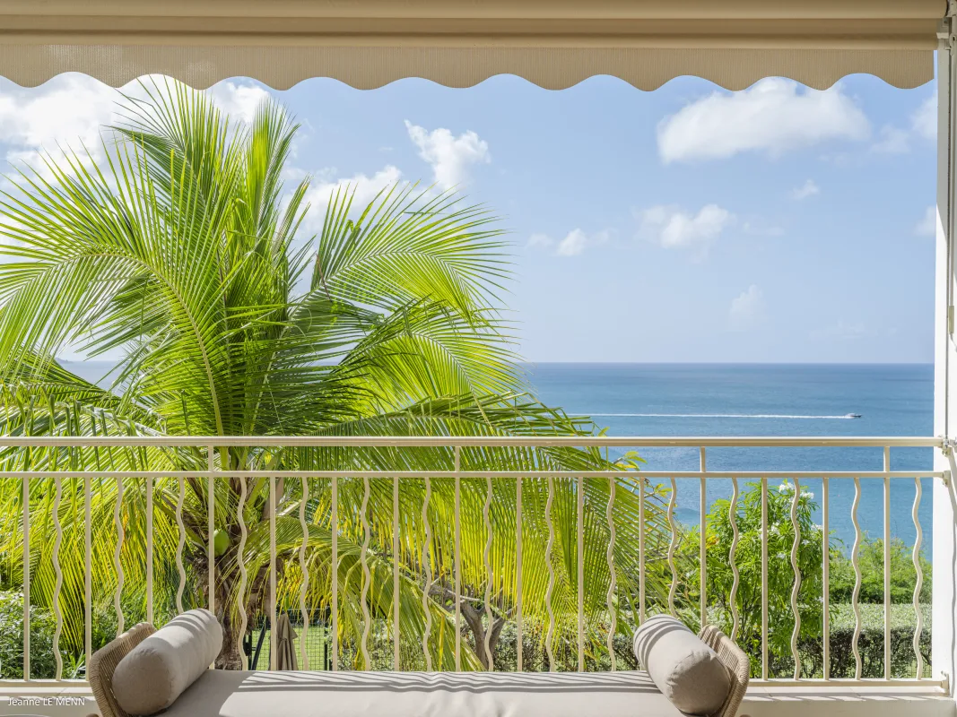 Villa Chez Paulette: Daybed on a covered balcony overlooking palm trees and the calm ocean