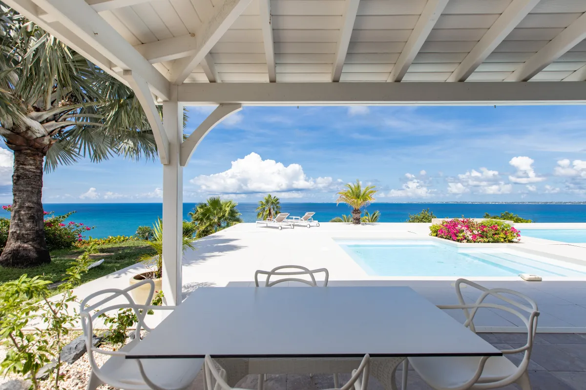 Villa Dreamin Blue: Covered terrace with dining table overlooking a swimming pool and wide ocean view