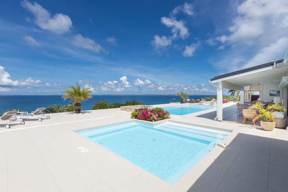 Villa Dreamin Blue: Sun terrace with two pools and loungers overlooking the ocean