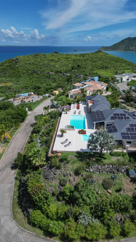 Villa Dreamin Blue: Aerial view of a hillside villa with a swimming pool, terrace, and distant ocean