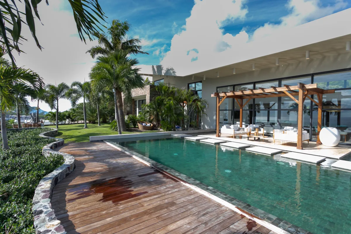 Villa Emeraude: Swimming pool with wooden deck alongside a modern villa and shaded outdoor lounge