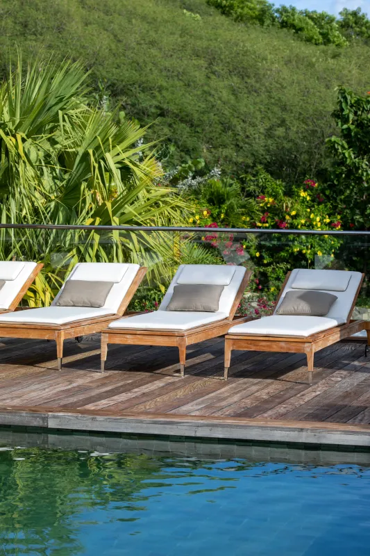 Villa Emeraude: Sun loungers on a wooden deck by the swimming pool with lush hillside behind
