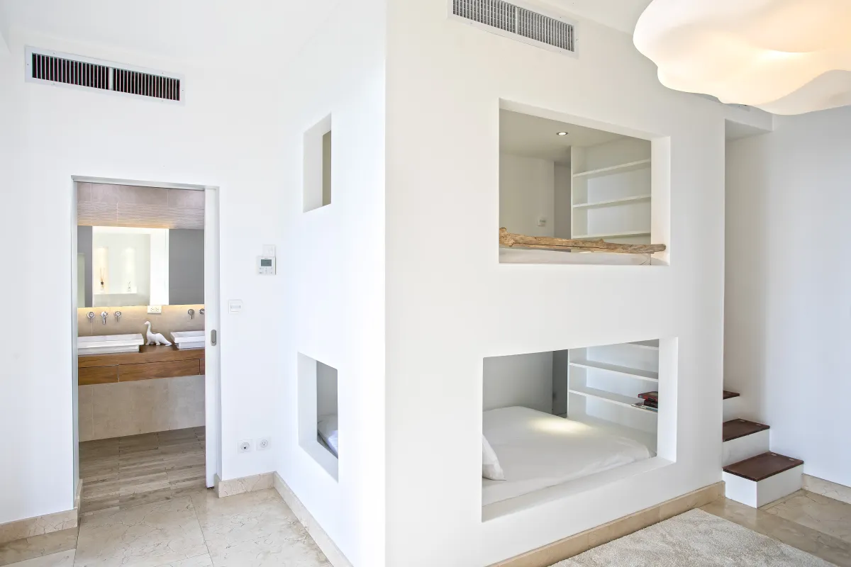 Villa Emeraude: Built-in bunk beds set into a white wall adjacent to an en-suite bathroom