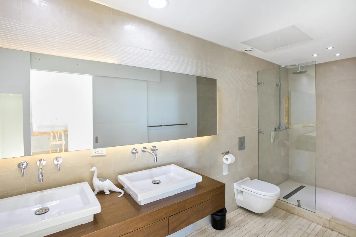 Villa Emeraude: Modern bathroom with double sink vanity, large mirror, wall-mounted toilet, and glass walk-in shower