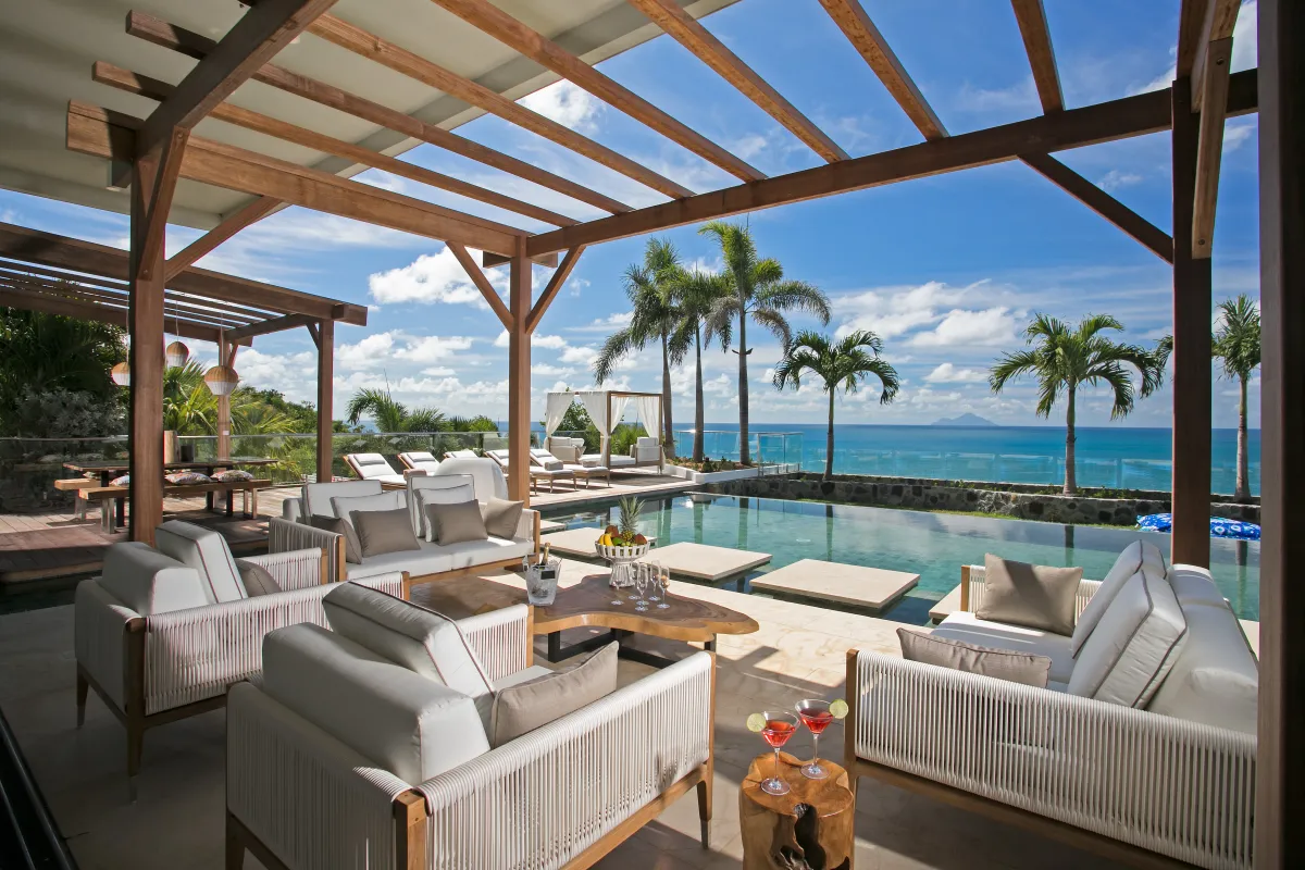 Villa Emeraude: Covered terrace lounge with outdoor seating overlooking a swimming pool and the ocean