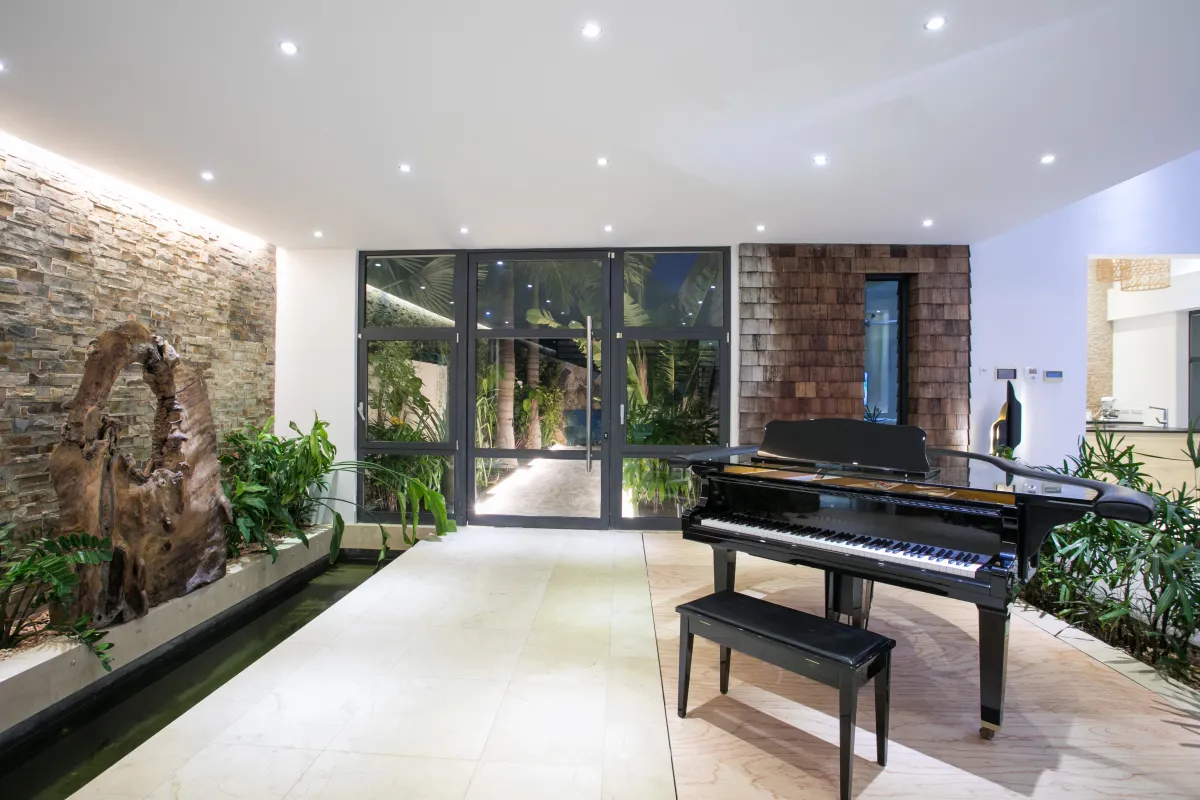 Villa Emeraude: Interior entryway with a black grand piano, indoor garden feature, and glass doors