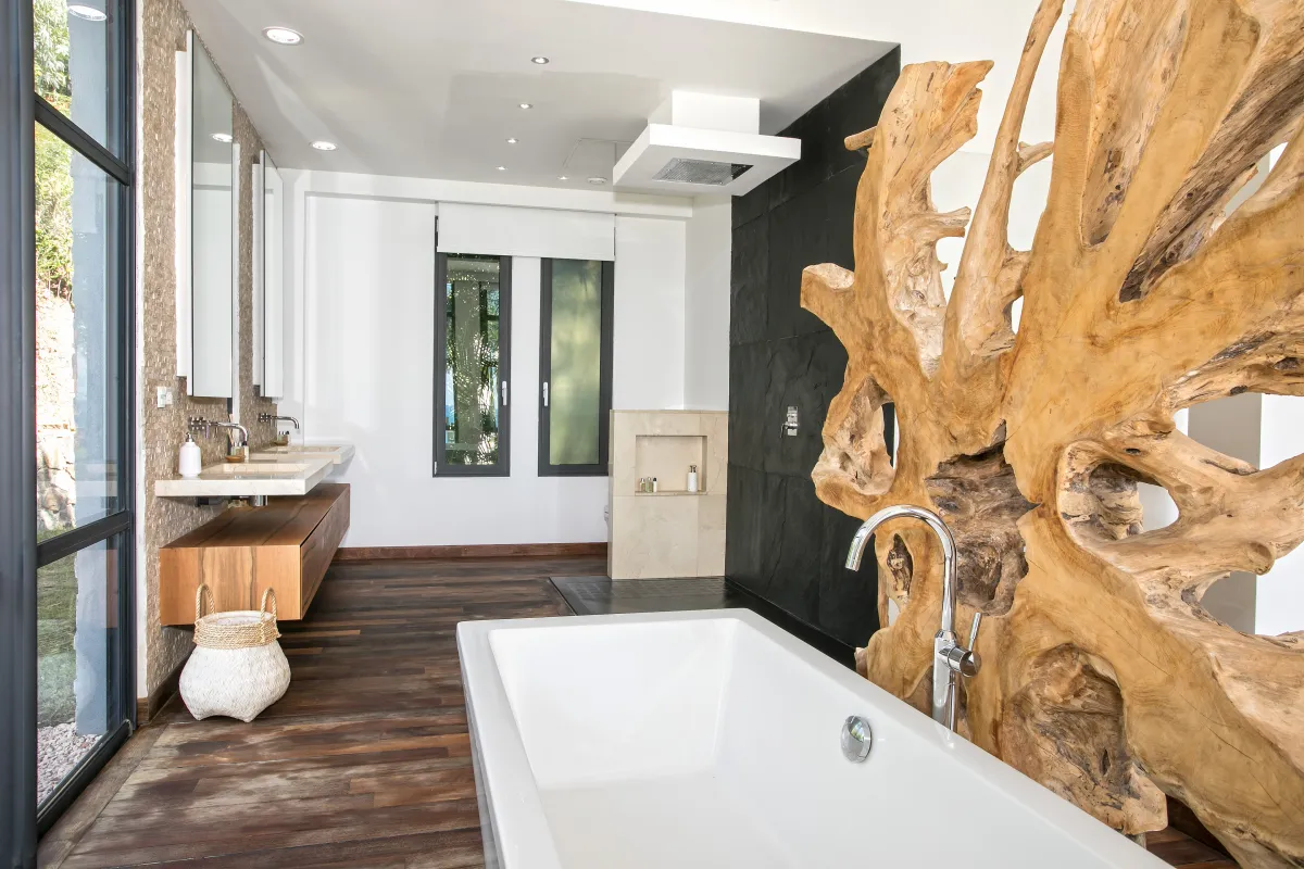 Villa Emeraude: Bathroom with freestanding soaking tub, floating double vanity, and large natural driftwood divider