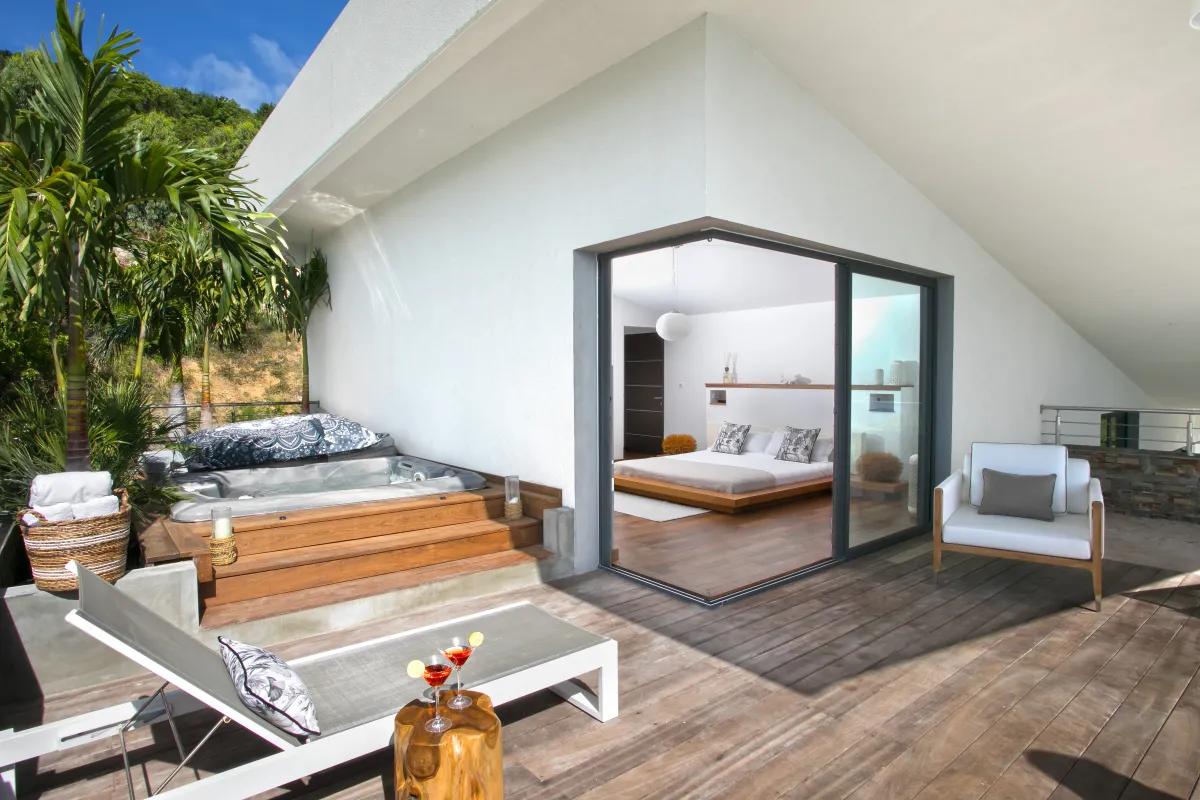 Villa Emeraude: Wooden terrace with sun lounger, hot tub, and sliding doors opening to a bedroom