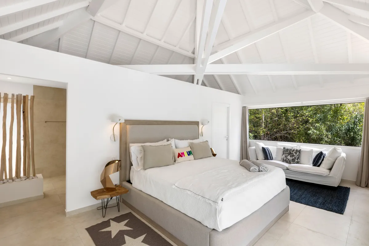 Villa Greystone: Bright bedroom with vaulted white ceiling, king bed, and a sofa by large window