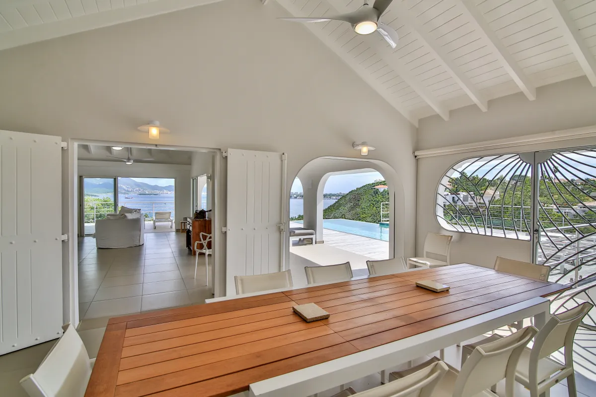 Villa Imagine: Covered dining area with a long wooden table opening to the swimming pool terrace