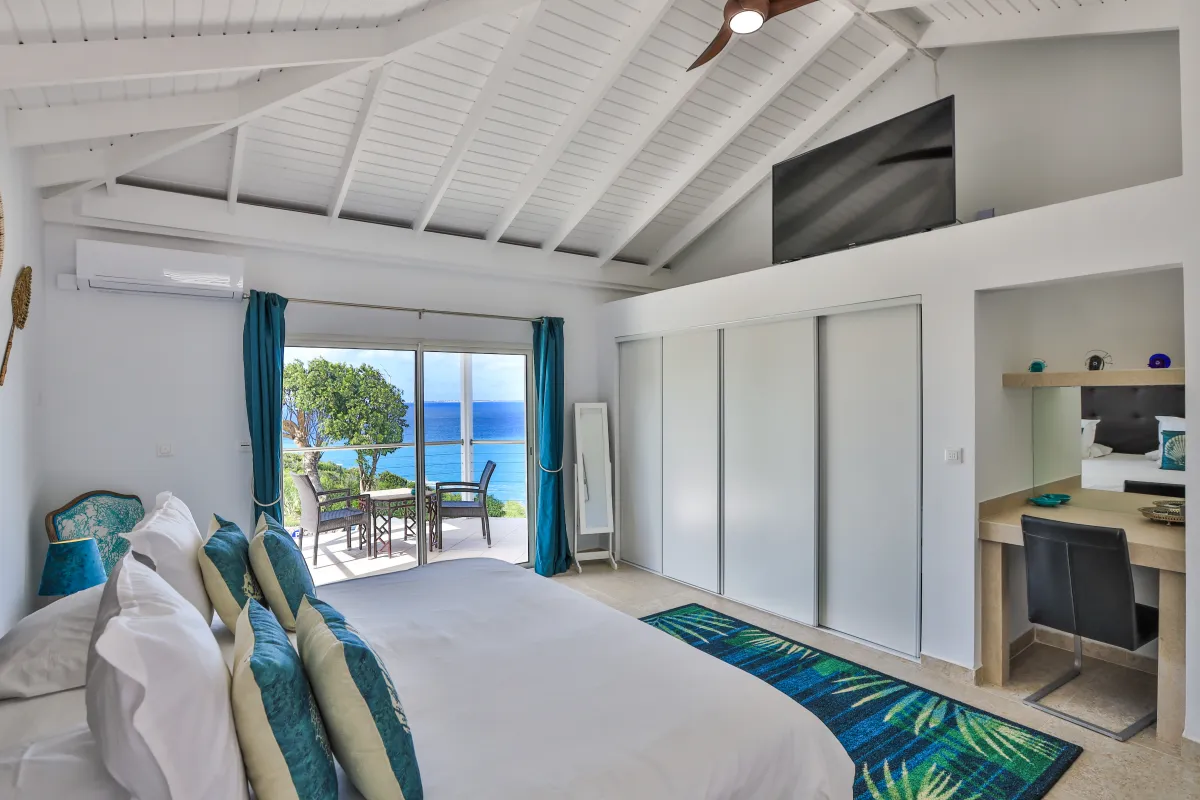 Villa Infinity Blue: Bedroom with vaulted ceiling and sliding glass doors leading to a terrace with sea view
