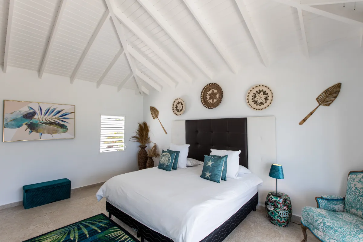 Villa Infinity Blue: Spacious bedroom with a king bed beneath a high vaulted white wood-beam ceiling