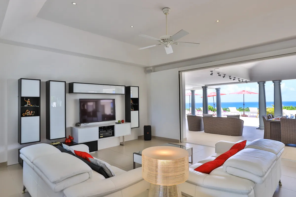 Villa Just in Paradise: Living room with white leather sofas opening to a covered terrace and ocean view