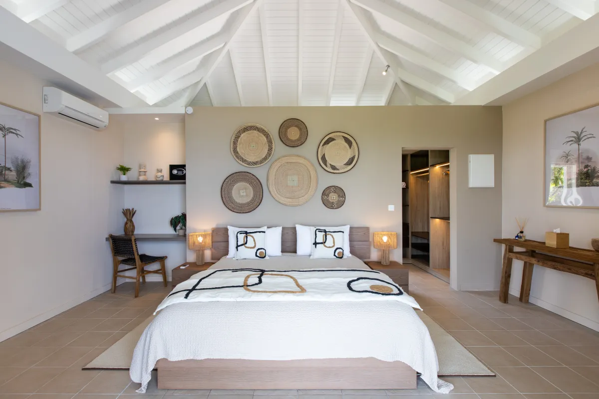 Villa Karukera: Bedroom with king bed, vaulted ceiling, woven wall decor, and walk-in closet