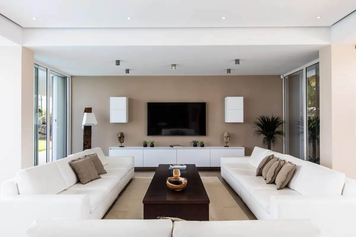 Villa Karukera: Living room with white sofas, a dark wood coffee table, and a wall-mounted television