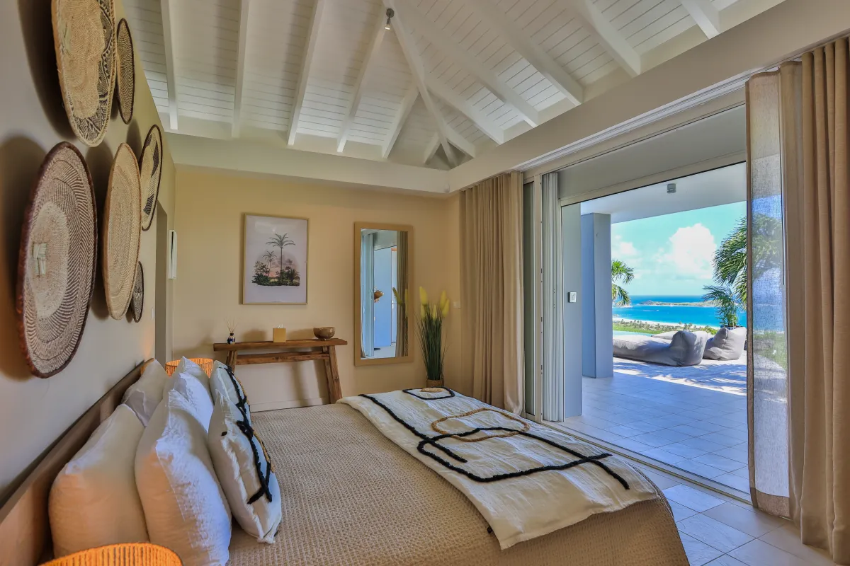 Villa Karukera: Bedroom with a king bed opening onto a terrace with sea views