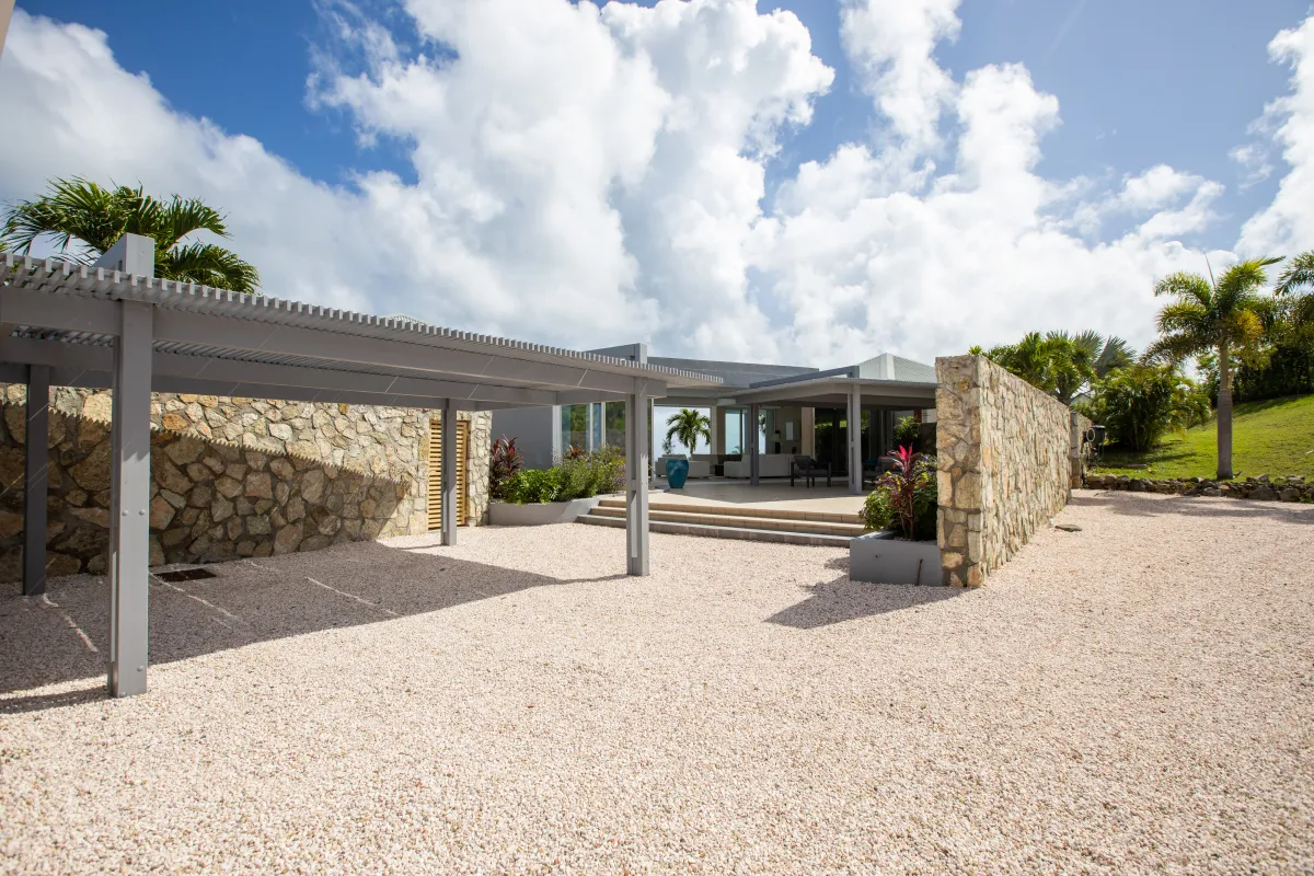 Villa Karukera: Gravel driveway with a shaded carport leading toward the entrance of a modern villa