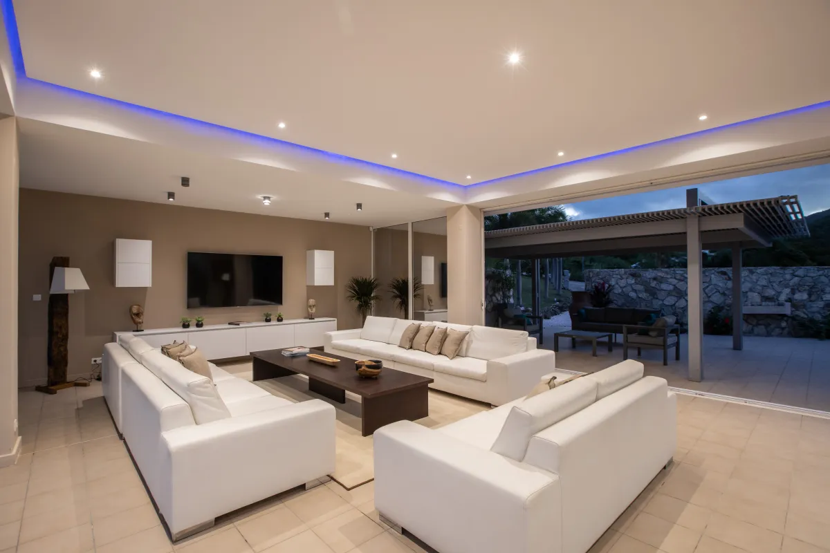 Villa Karukera: Modern living room with white sofas and sliding doors opening to an outdoor patio