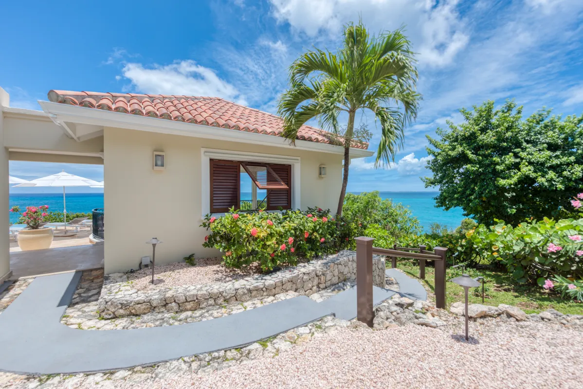 Villa La Dacha: Exterior view of a villa with tropical garden pathway overlooking the ocean