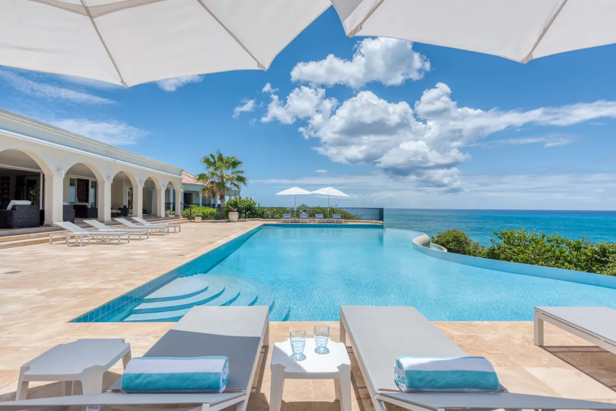 Villa La Dacha: Infinity swimming pool and lounge chairs on a sunny terrace overlooking the sea