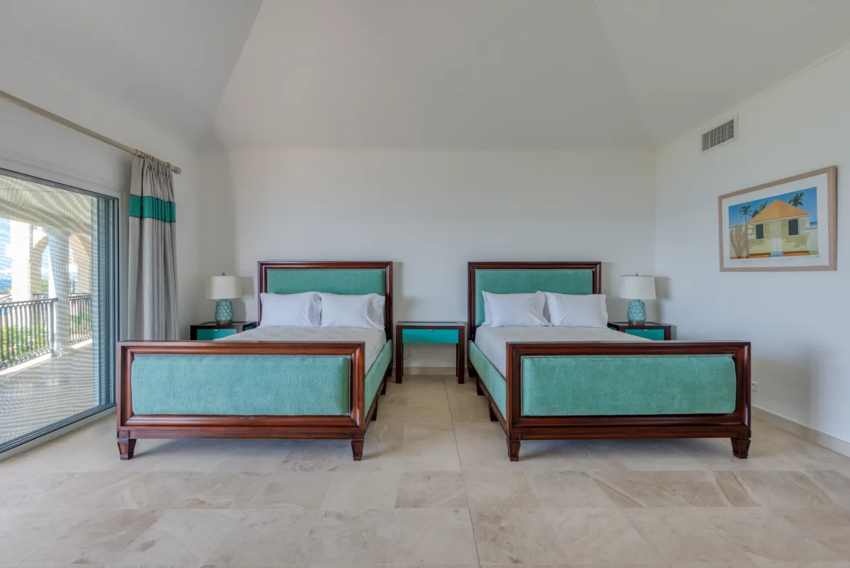 Villa La Dacha: Bedroom with two queen beds featuring turquoise upholstery and sliding glass door to a terrace