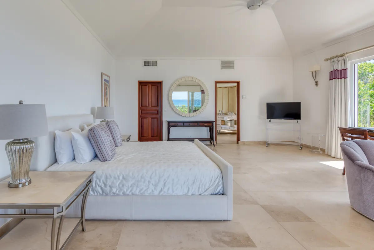 Villa La Dacha: Spacious bedroom with a king bed, decorative wall mirror, and television