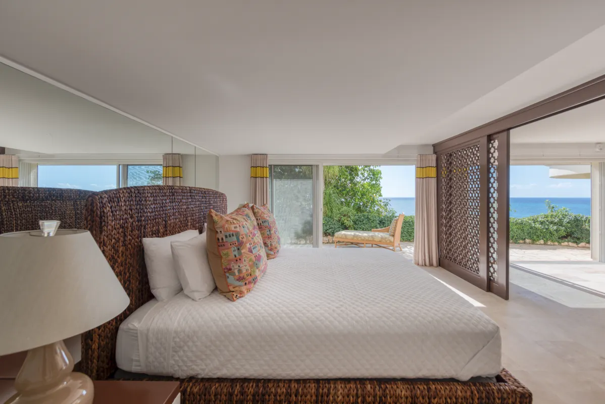 Villa La Dacha: Bedroom with woven bed frame opening onto a terrace overlooking the sea
