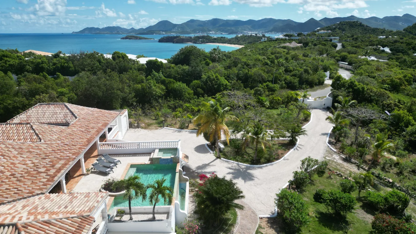 Villa La Rose Du Desert: Aerial view of a villa with a swimming pool overlooking the ocean and green hills