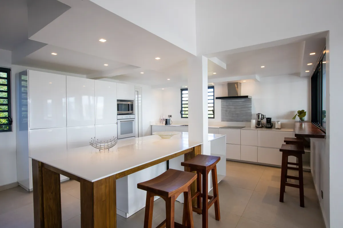 Villa La Siesta: Modern white kitchen with a large center island and wooden bar stools