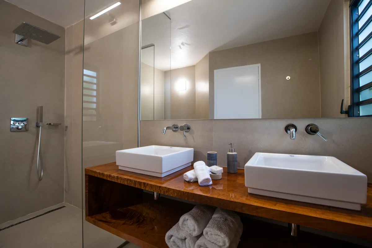 Villa La Siesta: Modern bathroom featuring double vessel sinks on a wooden vanity and a walk-in shower
