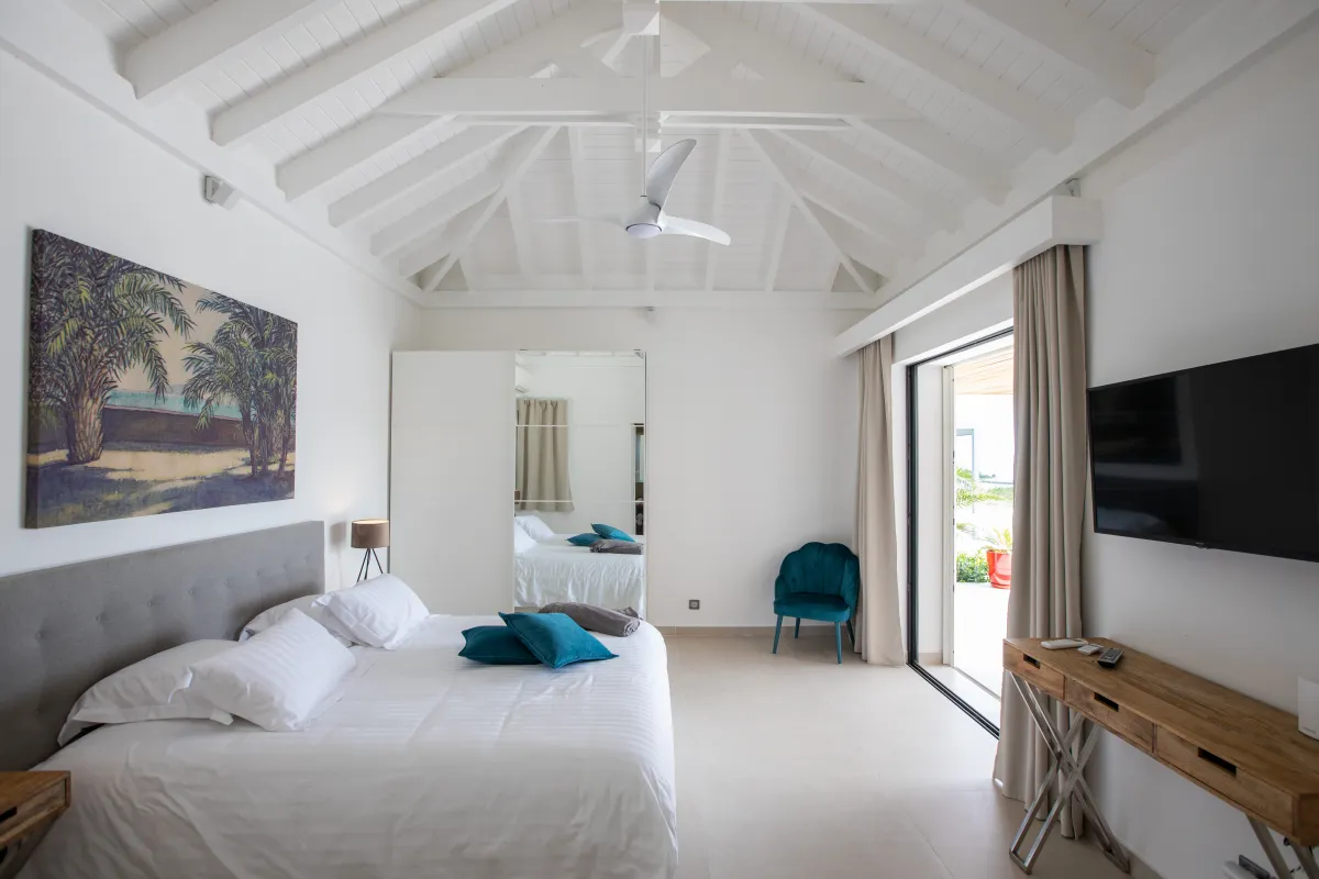 Villa La Siesta: Bright bedroom with vaulted ceiling, large bed, and sliding glass doors to a terrace