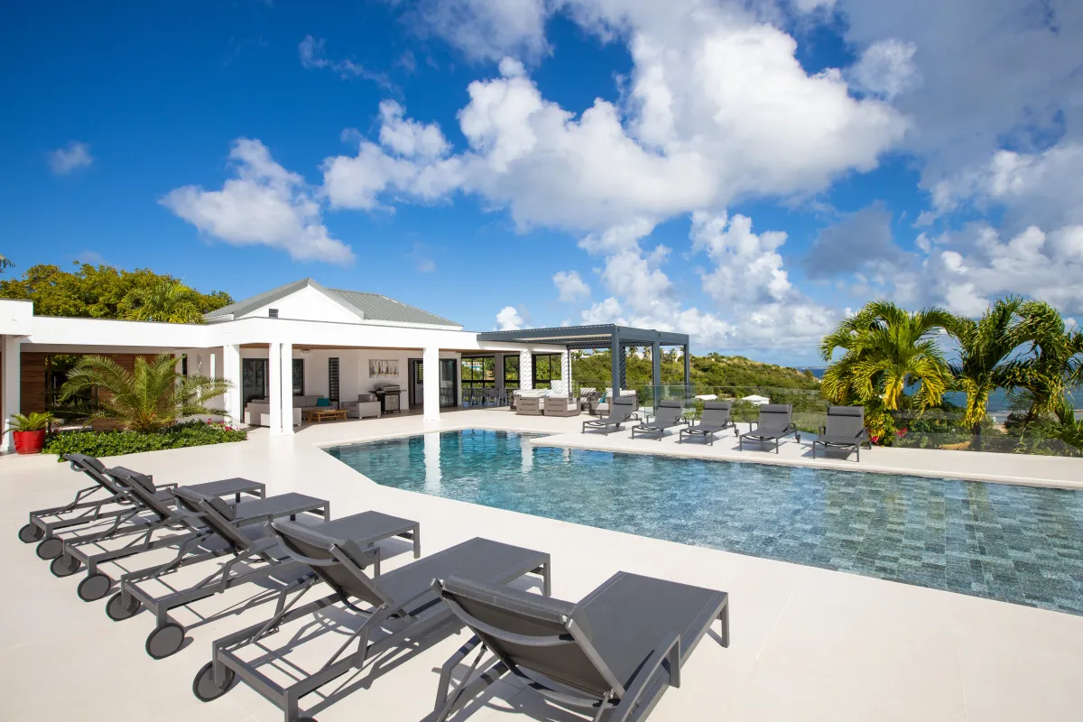 Villa La Siesta: Swimming pool surrounded by sun loungers on a terrace overlooking the tropical landscape