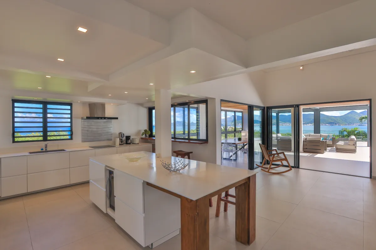 Villa La Siesta: Modern open-plan kitchen with central island opening onto a terrace with sea views