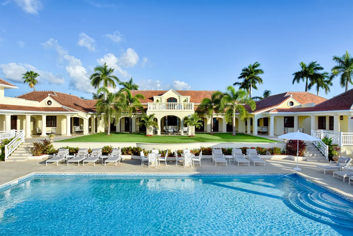 Villa Le Chateau Des Palmiers: Large swimming pool with sun loungers on a stone deck fronting a villa
